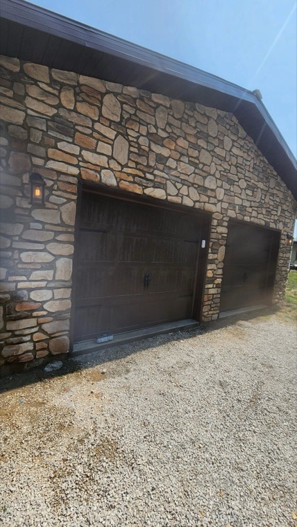 Stone-faced garage with two new garage doors