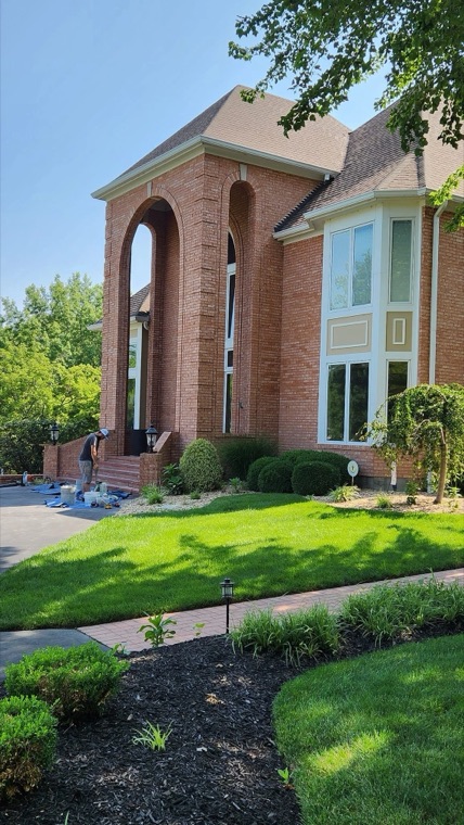 Two-story brick home with work under way at the front entry