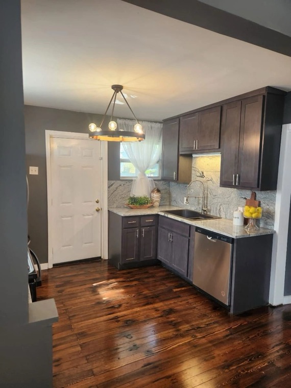 Remodeled kitchen with dark cabinets and stone countertops